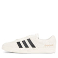 White sneaker with black stripes on a white background