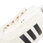 Close-up of a white sneaker with black stripes on a white background