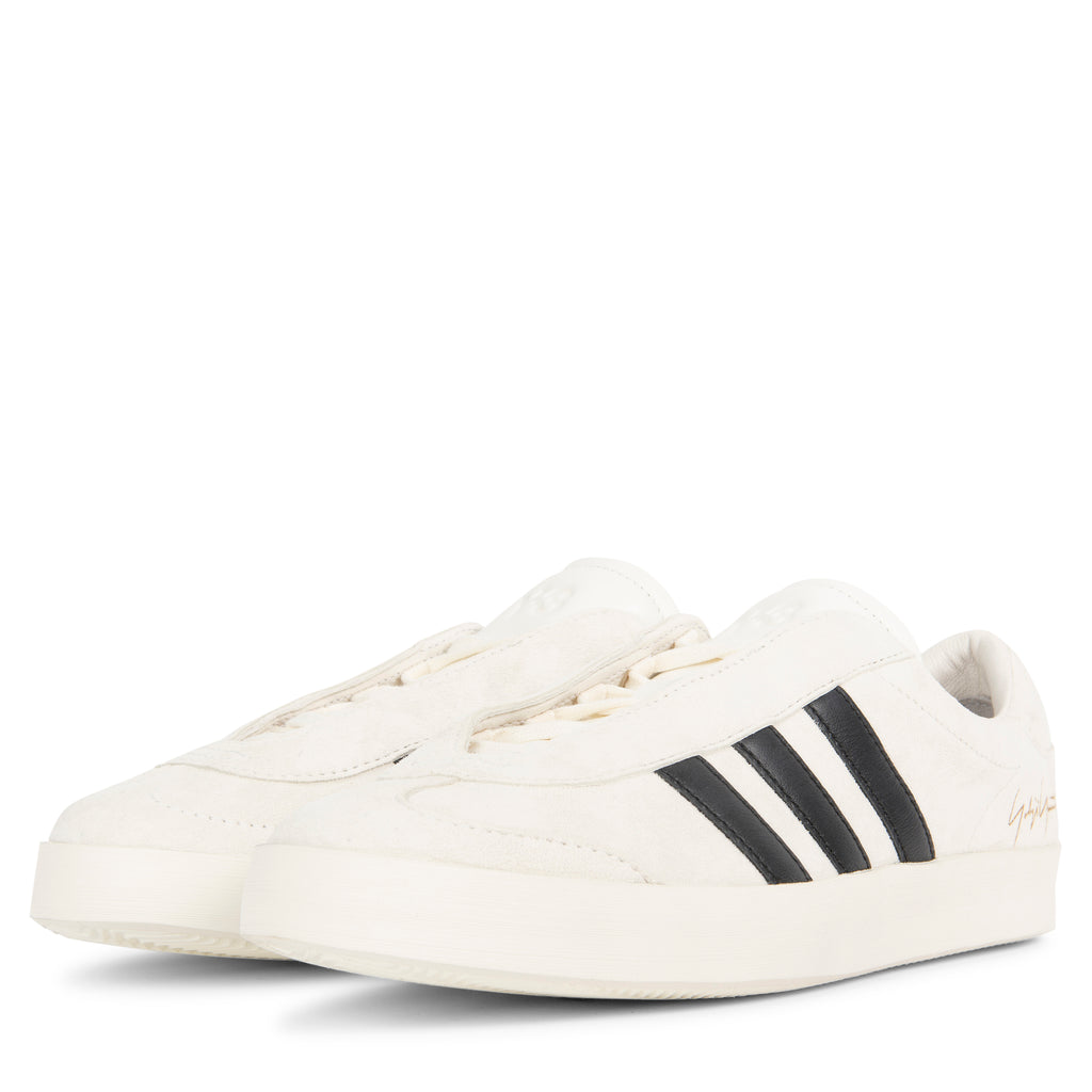 White sneakers with black stripes on a white background